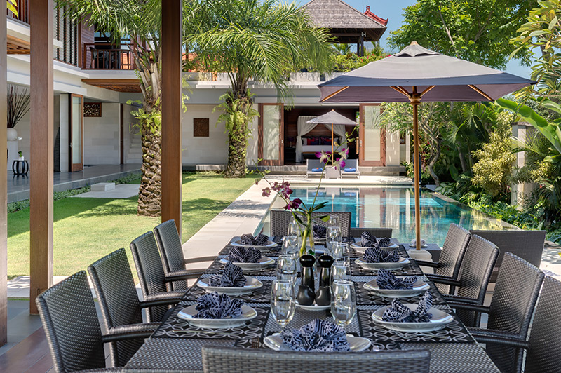 dinner table beside pool luxury villa bali