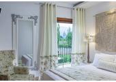 bedroom with lcurtains in light color in corfu villa